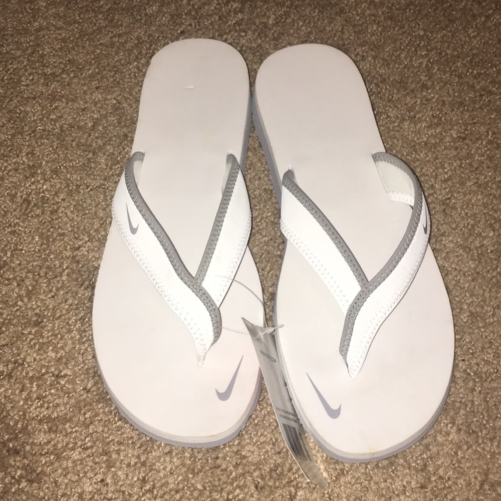 White and grey Nike flip flops